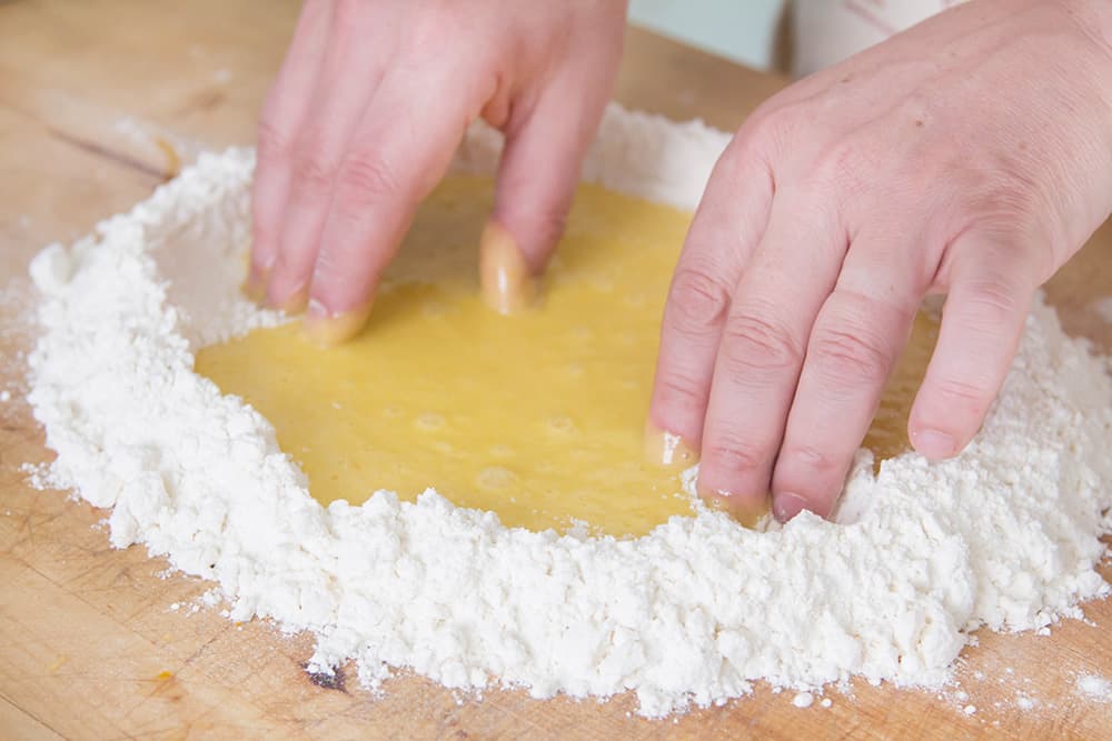 Mixing egg mixture with flour.