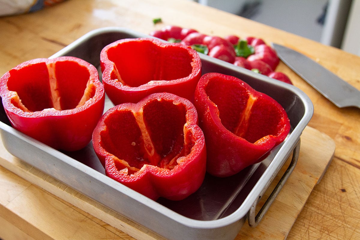 Topepo red bell peppers cut and placed in a baking dish.