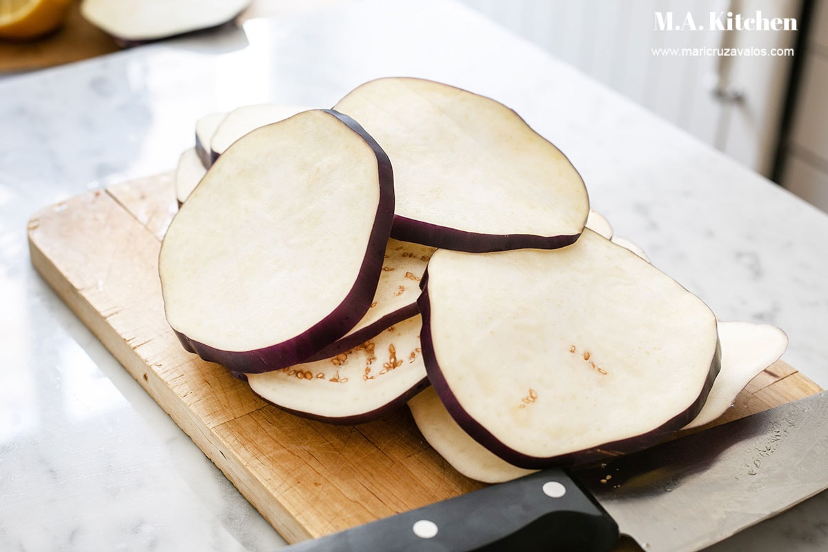 Eggplant sliced on a cutting board.