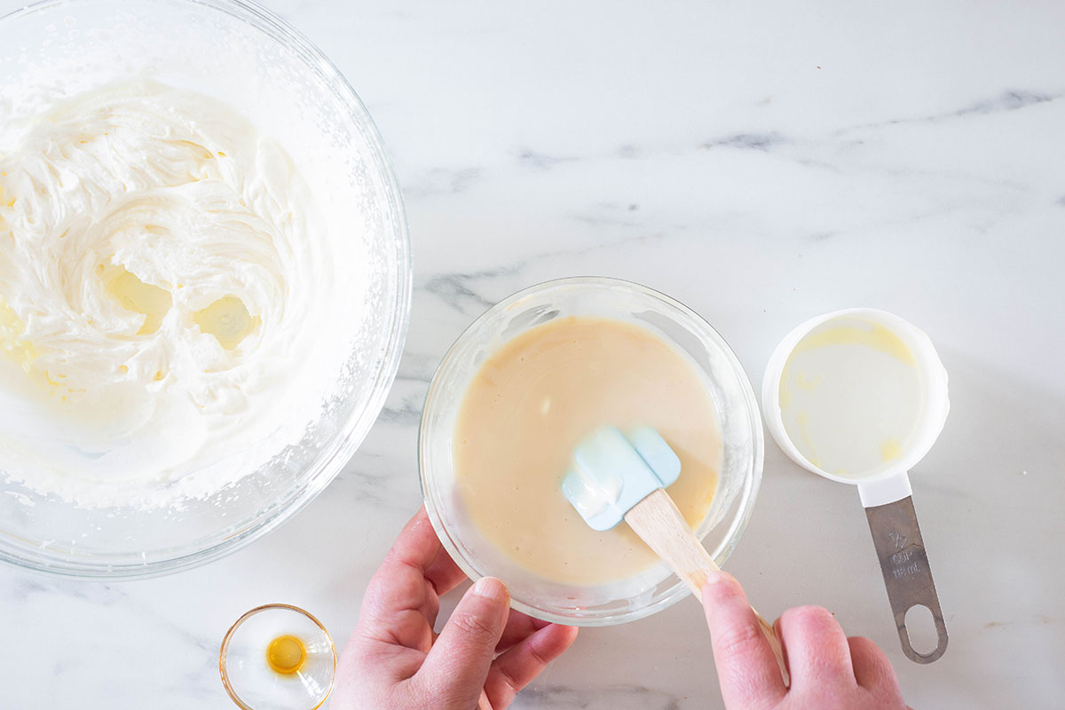 Mixing condensed milk, vanilla extract and a bit of whipped cream into a small bowl to make stracciatella gelato.