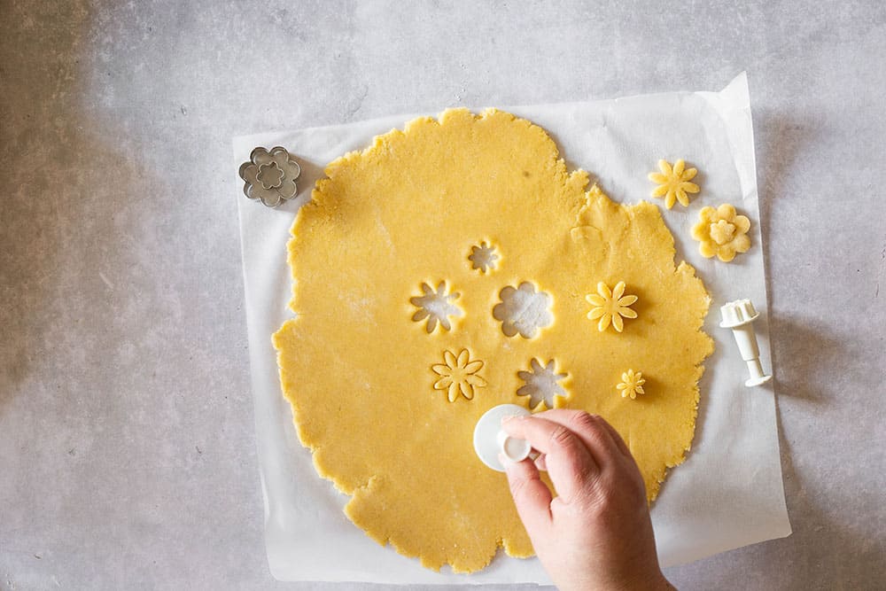 Cutting flowers in the rolled dough.