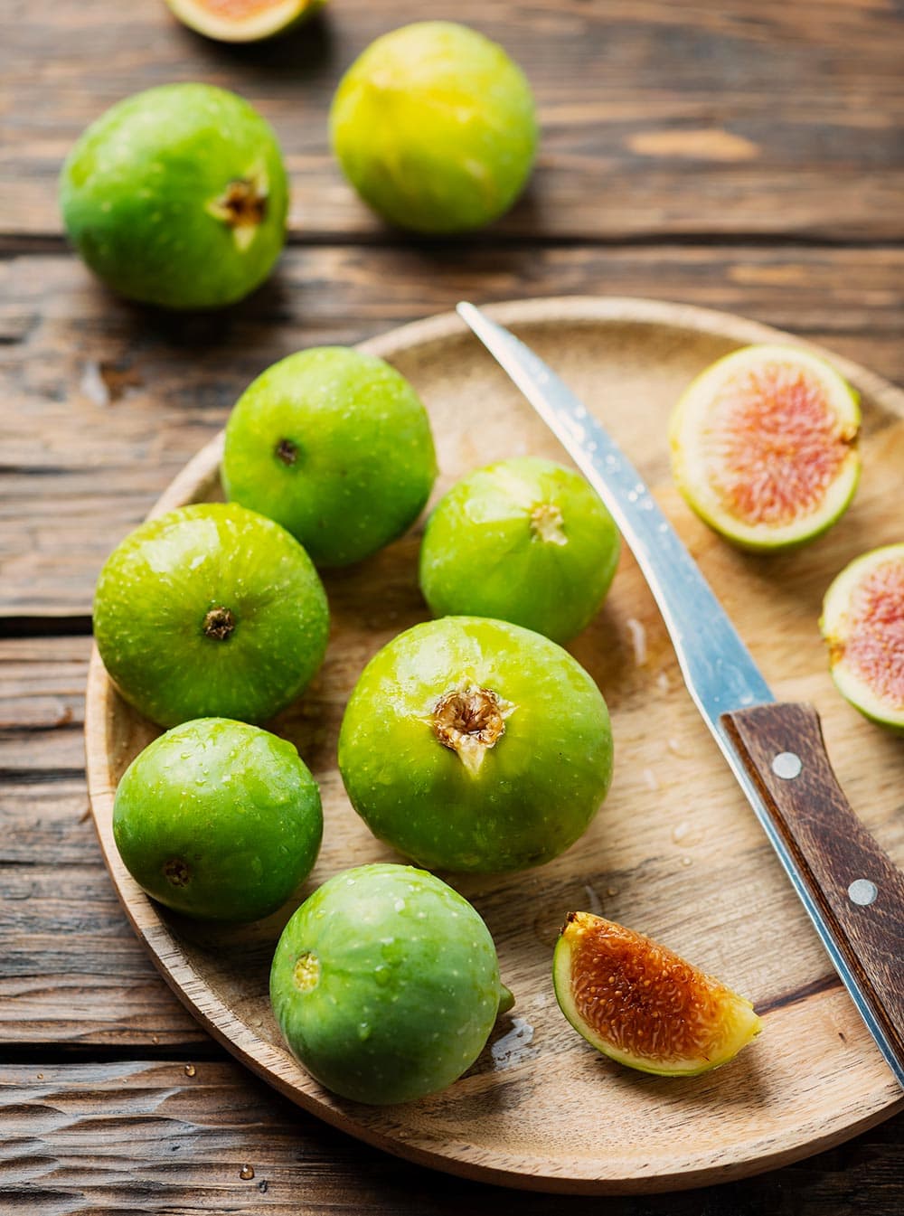 Fresh figs while and cut on a wooden plate.