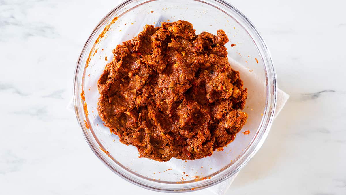 Combined ground pork meat with chile and spices sauce in a bowl.