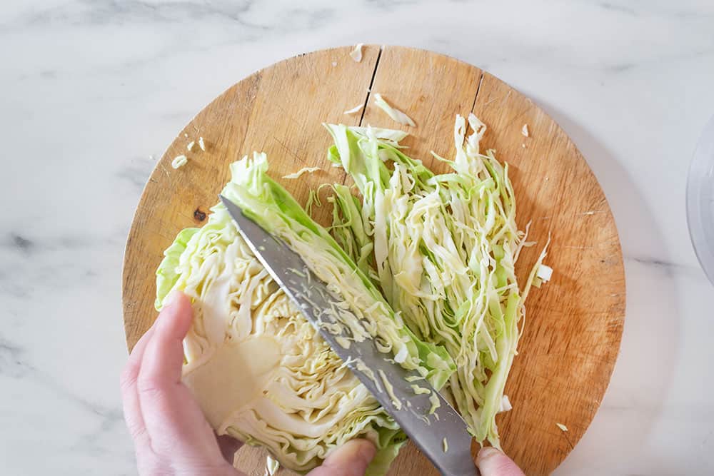 Cutting cabbage with a knife.