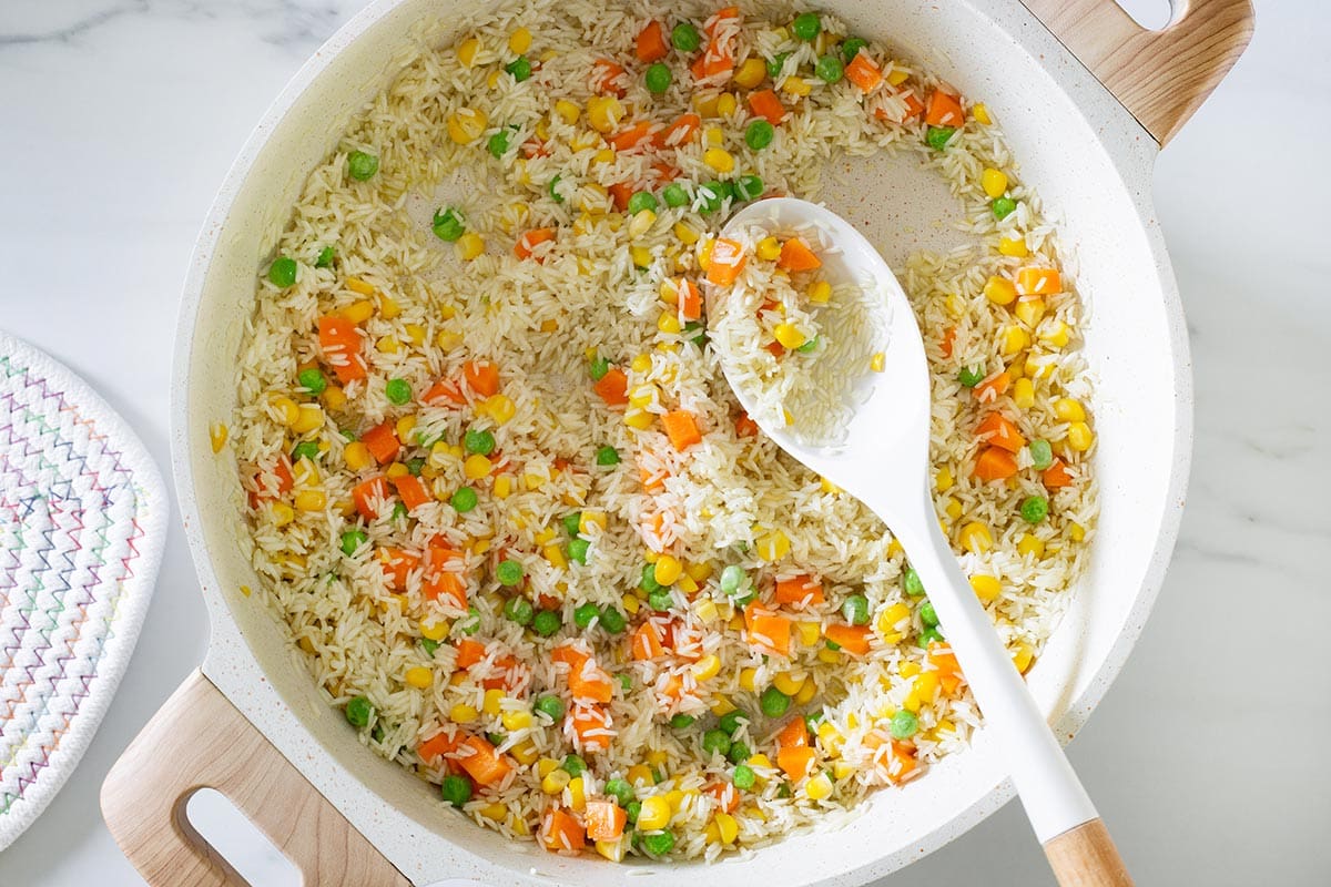 Rice sautéed with vegetables on a pan.