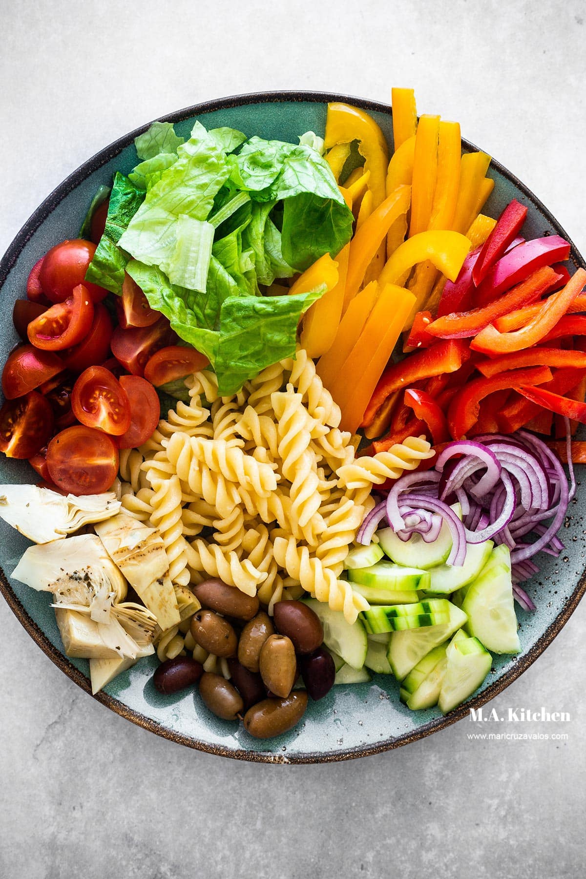 A plate with ingredients for zesty Italian pasta salad.