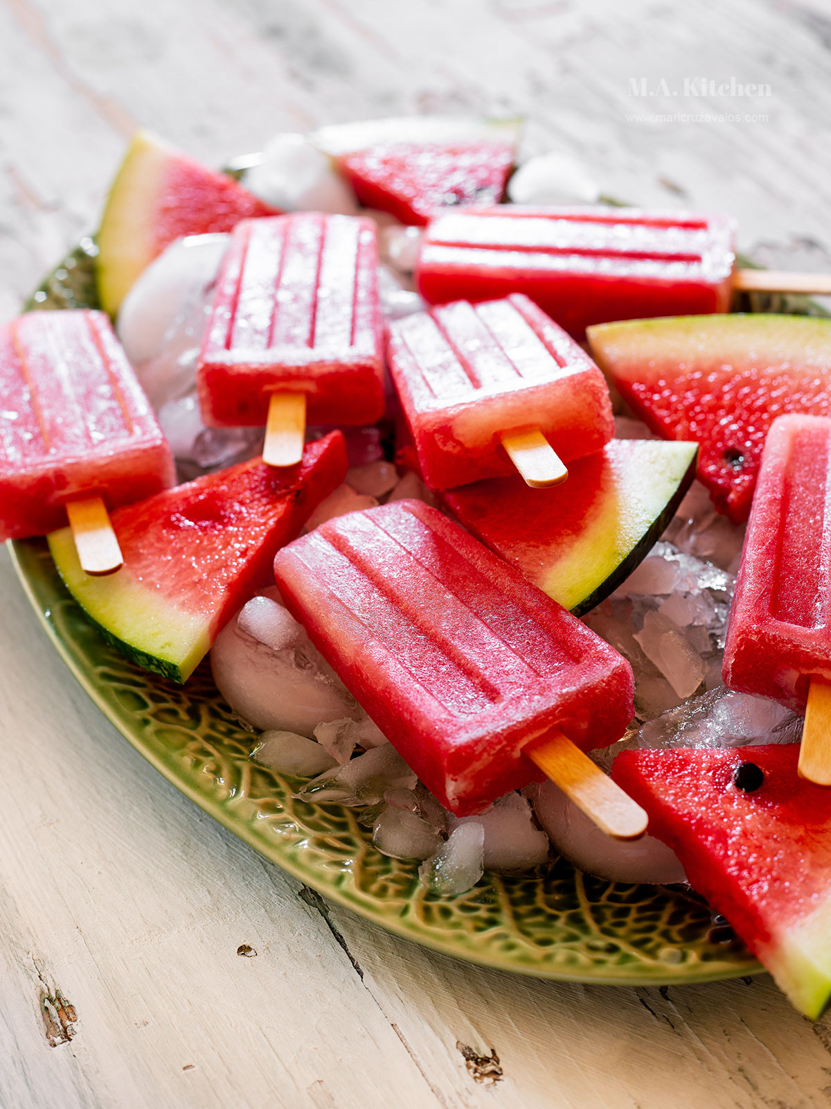 Mexican paletas de sandía, aka watermelon paletas in a plate with crushed ice.