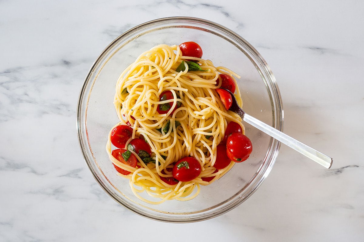 Tossed pasta with cherry tomatoes on a bowl.