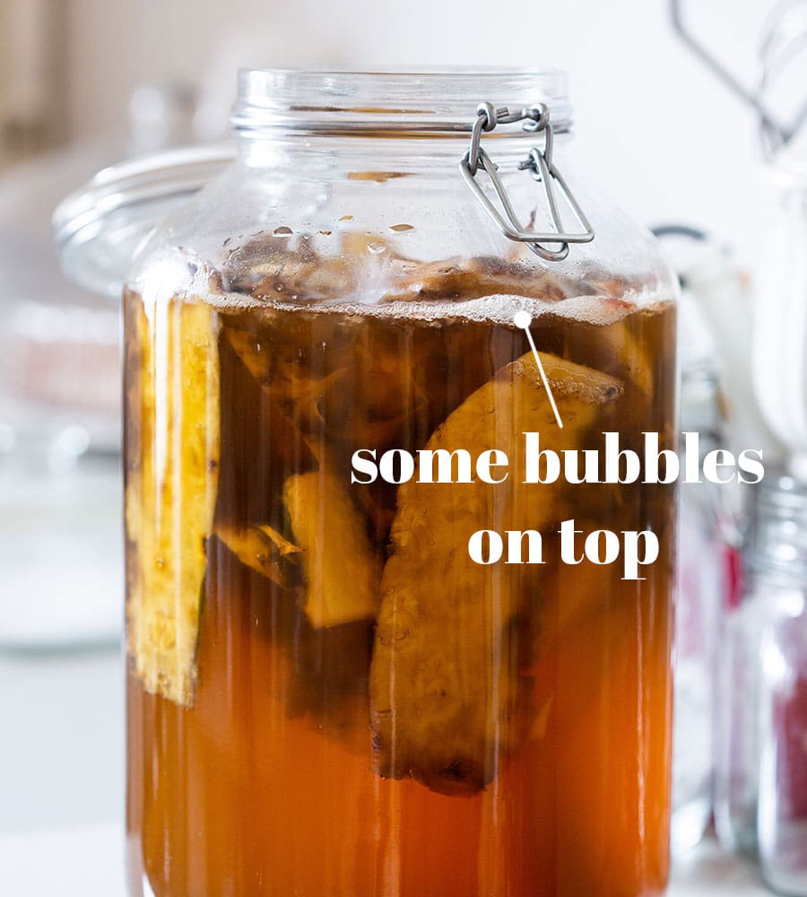 The jar from front showing some bubbles on top of liquid.