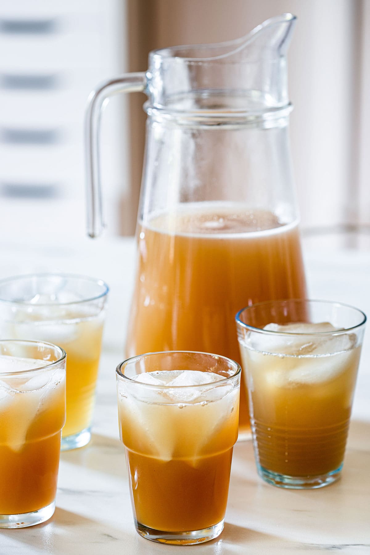 Tamarindo drink, also known as agua de tamarindo, on a pitcher and served in glasses with ice.