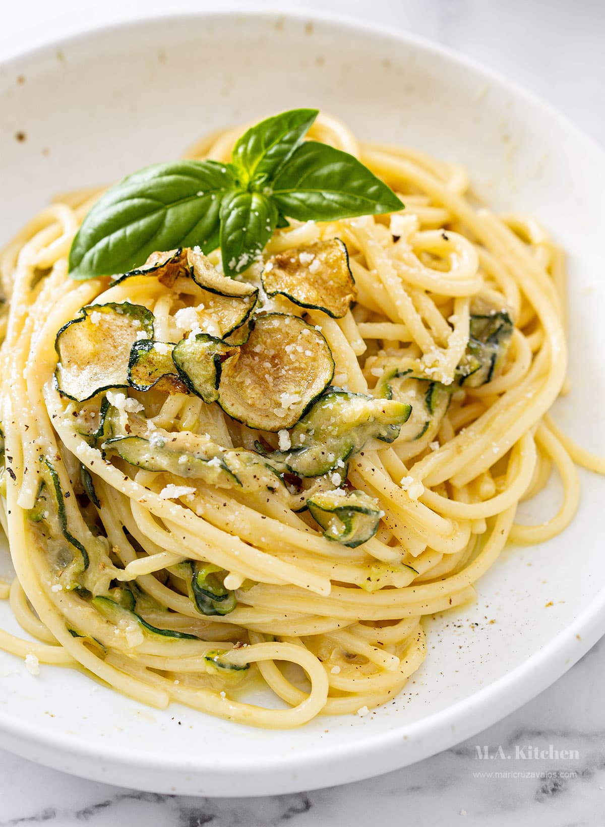Spaghetti Alla Nerano in a plate garnished with fresh basil leaves.