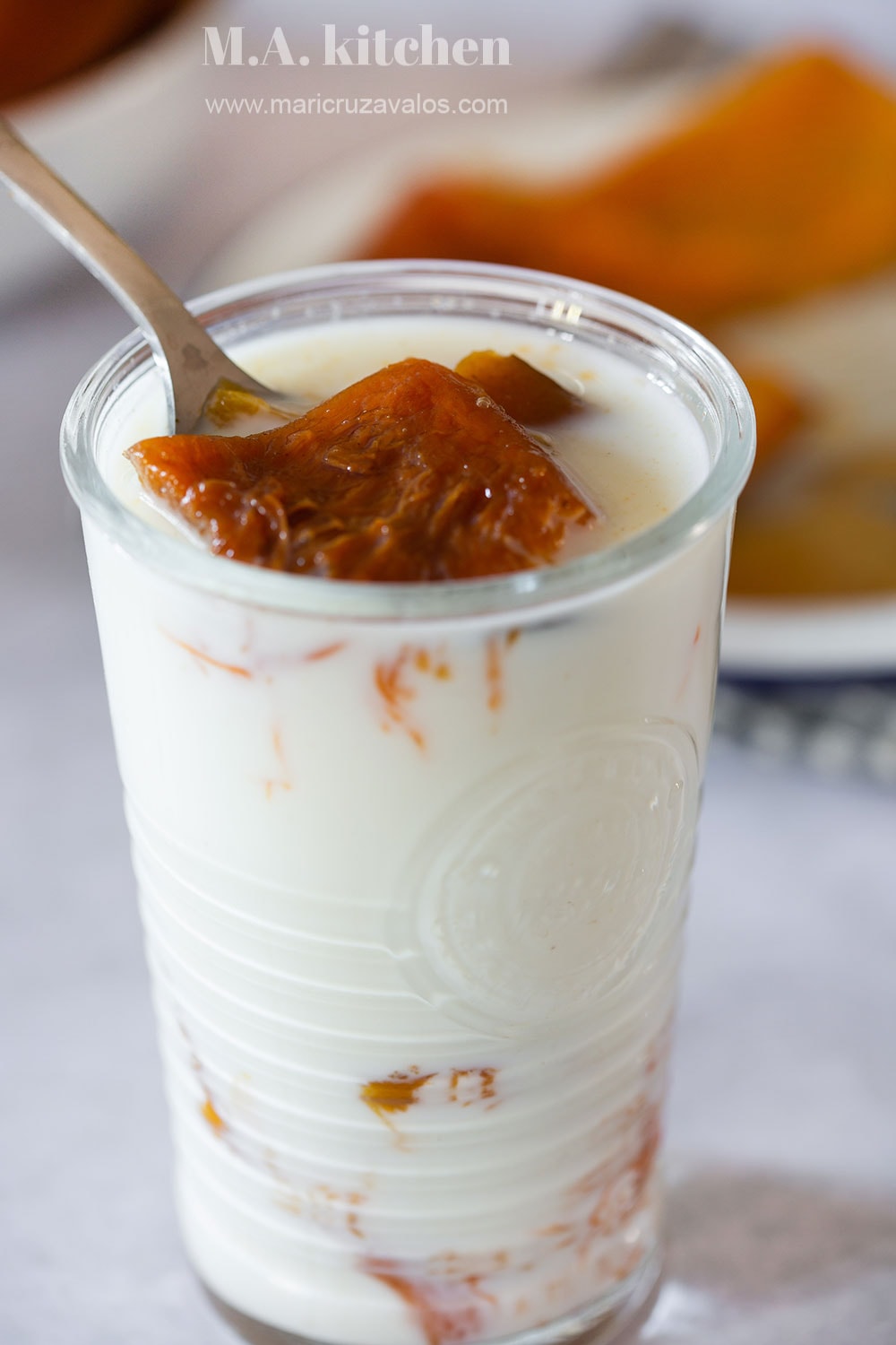 A glass of milk with Mexican candied pumpkin inside.