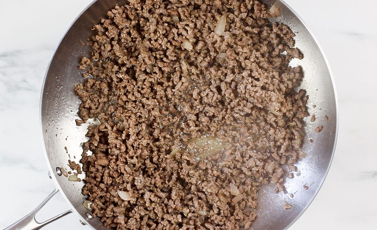 Browned ground beef in a pan.