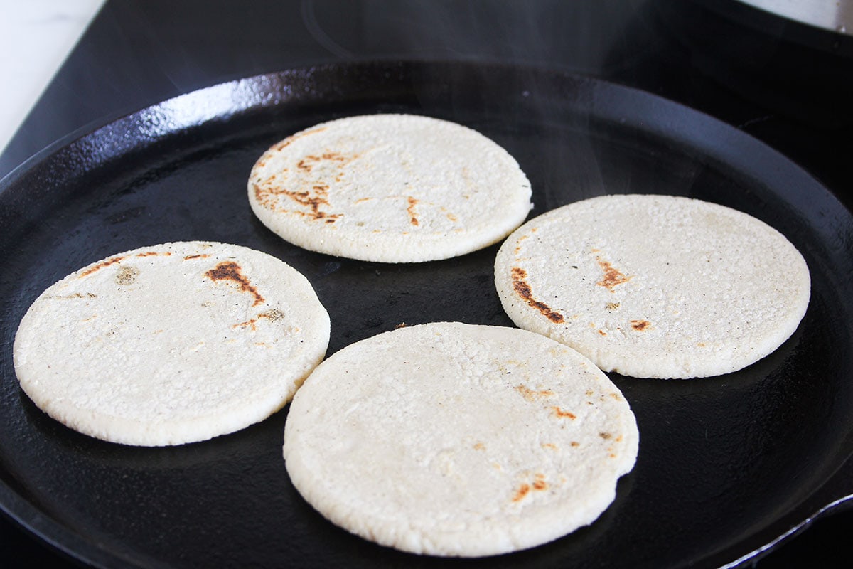 A comal with four picaditas cooking.