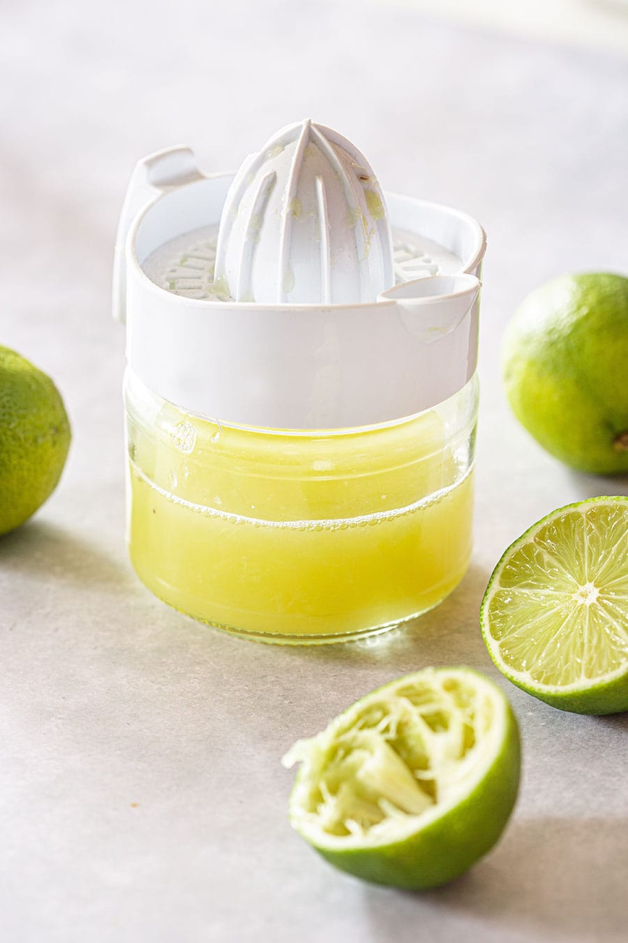 A citrus juiced with lime juice and some limes on the side.