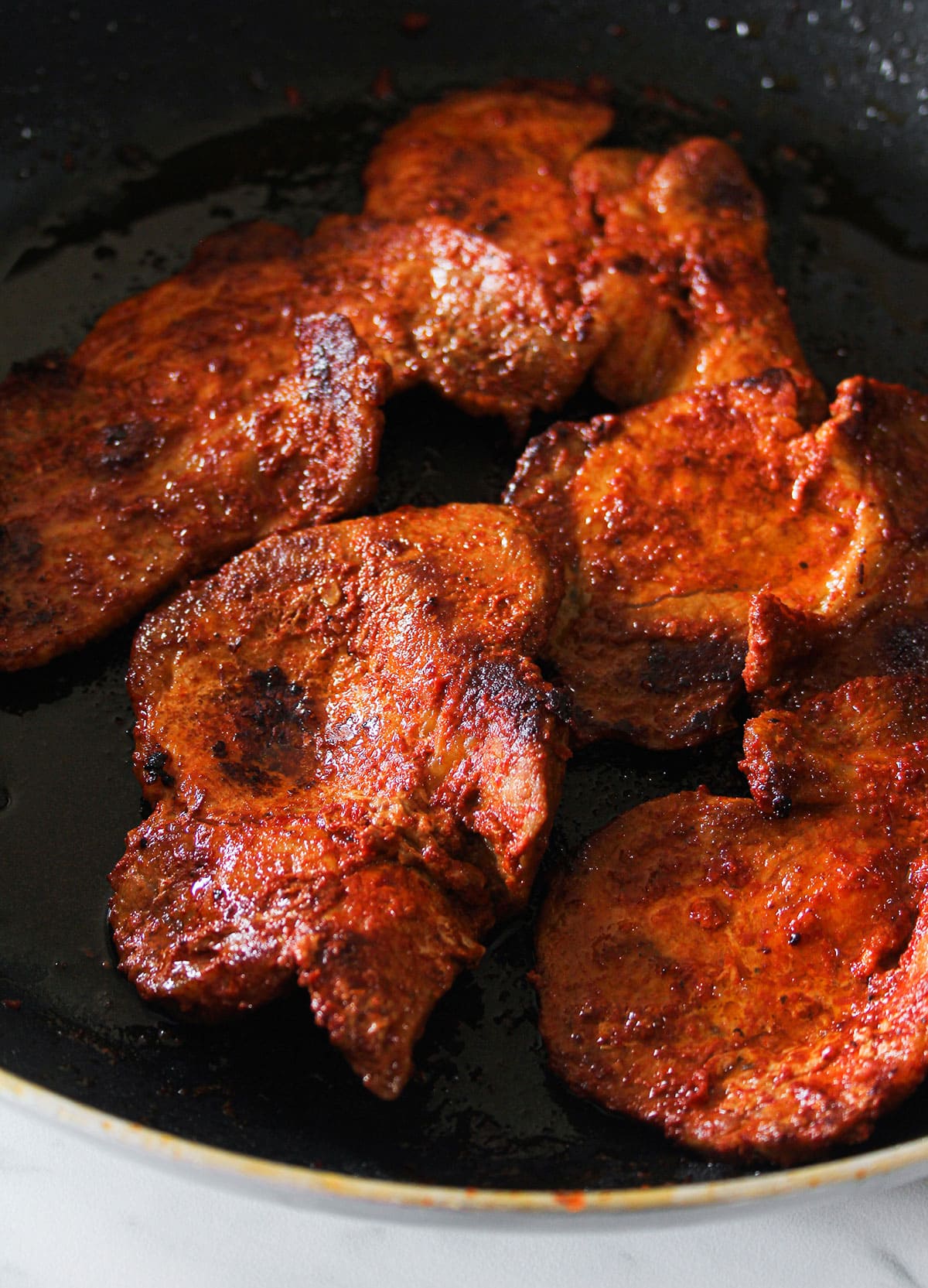 Cooked meat for tacos de adobada in a pan.