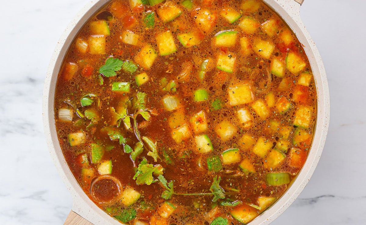 Water added to the pot with vegetables and sauce.