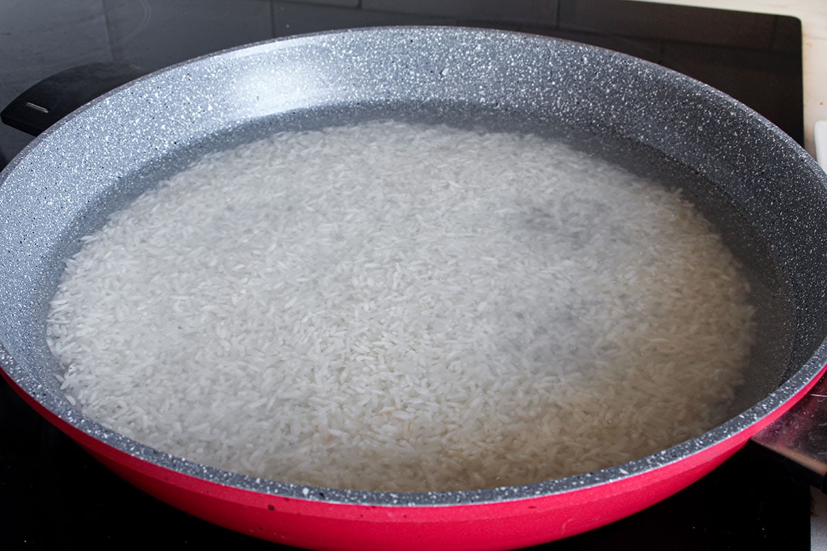 Morisqueta rice with water in a deep pan.