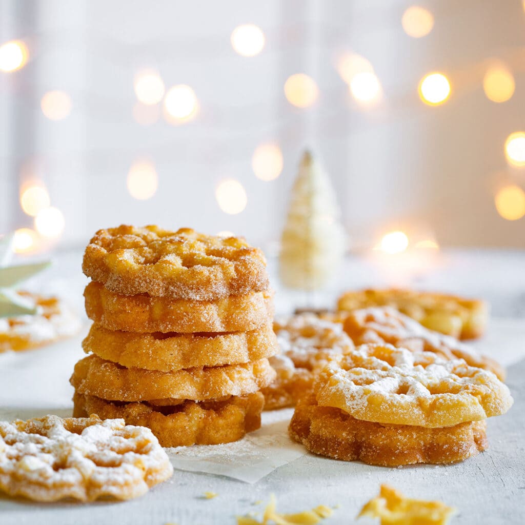 Buñuelos de Viento with Christmas lights in the background.