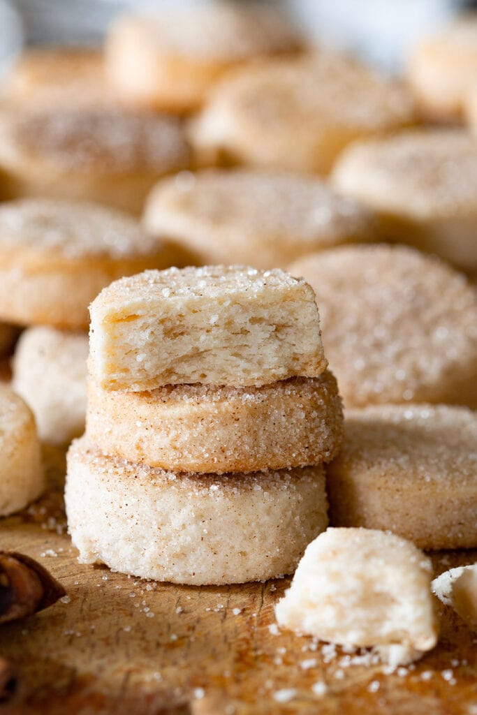 Pan de polvo cookies piled, with one cookie cut to see the crumbly and flaky texture inside.