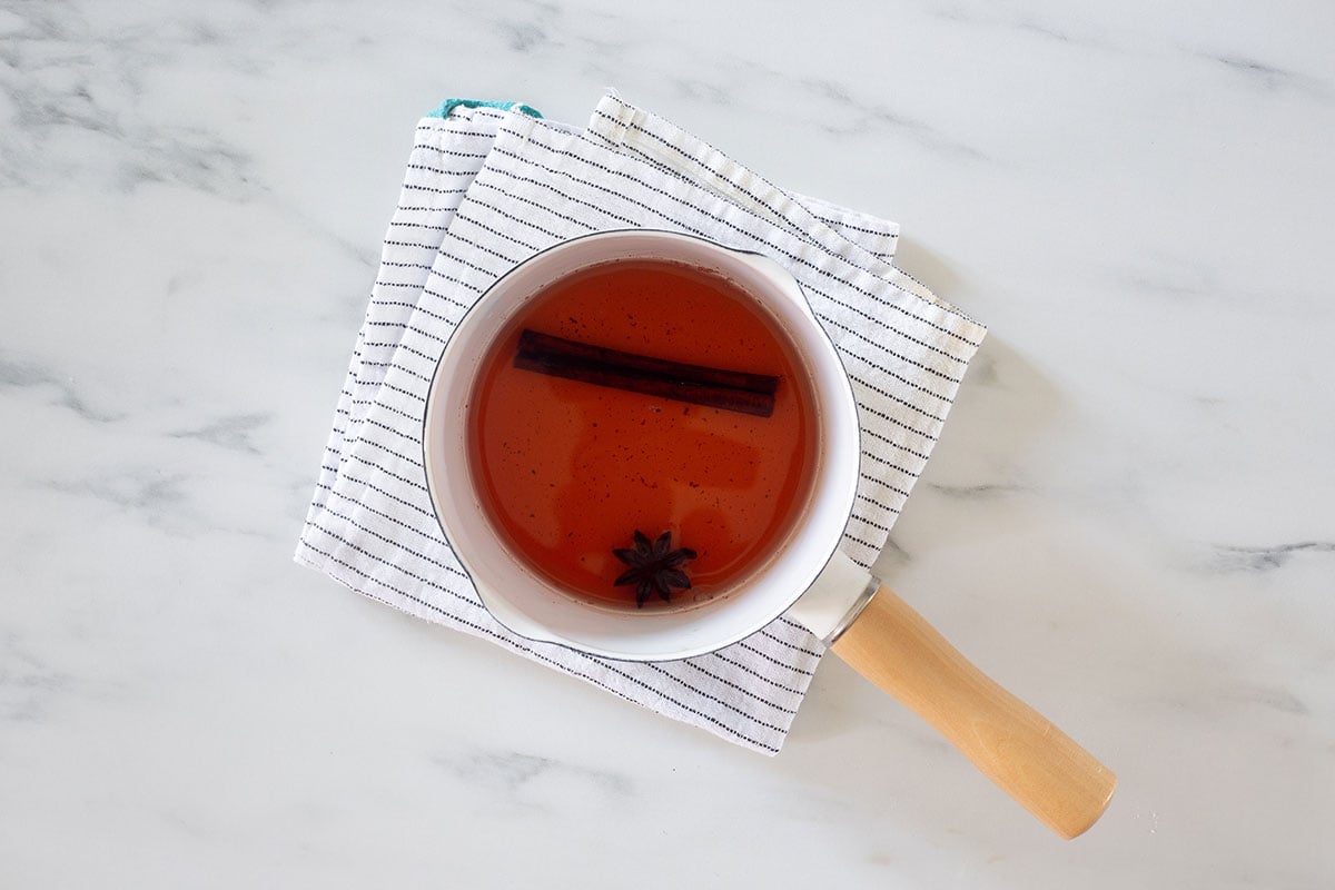 Cinnamon and anise tea in a white small pot.
