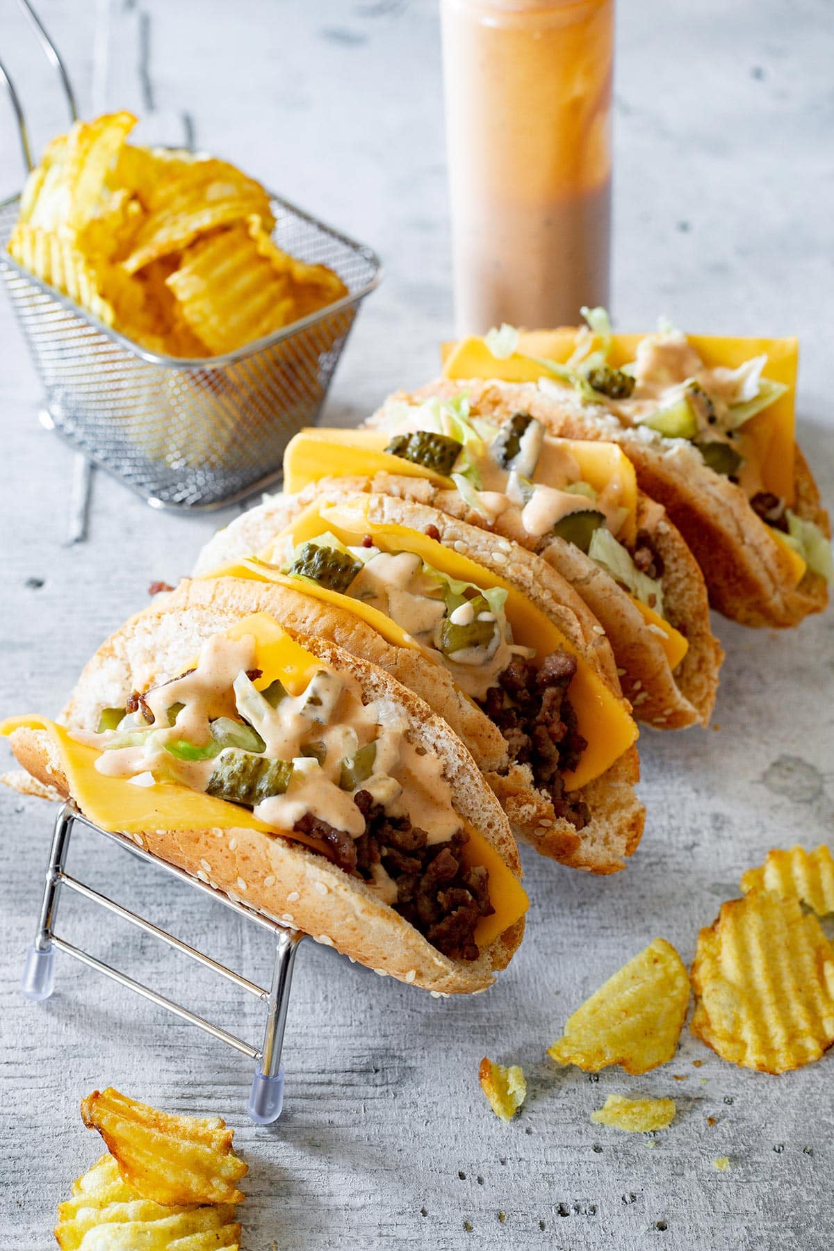 Big Mac Tacos in a taco holder with potato chips on the side.