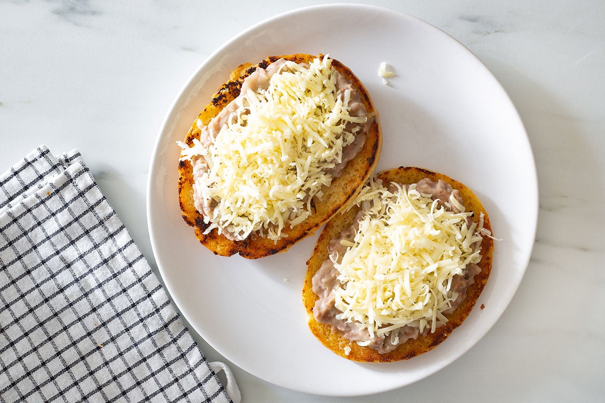 Telera rolls topped with shredded cheese.