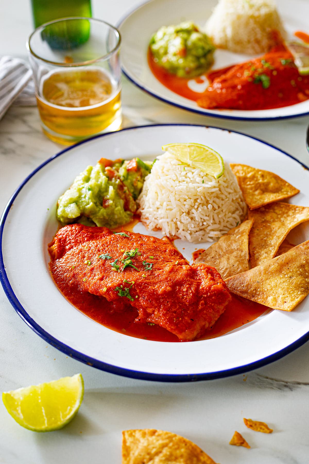 Pescado a la diabla served in a plate with buttery rice, guacamole, and tortilla chips on the side.