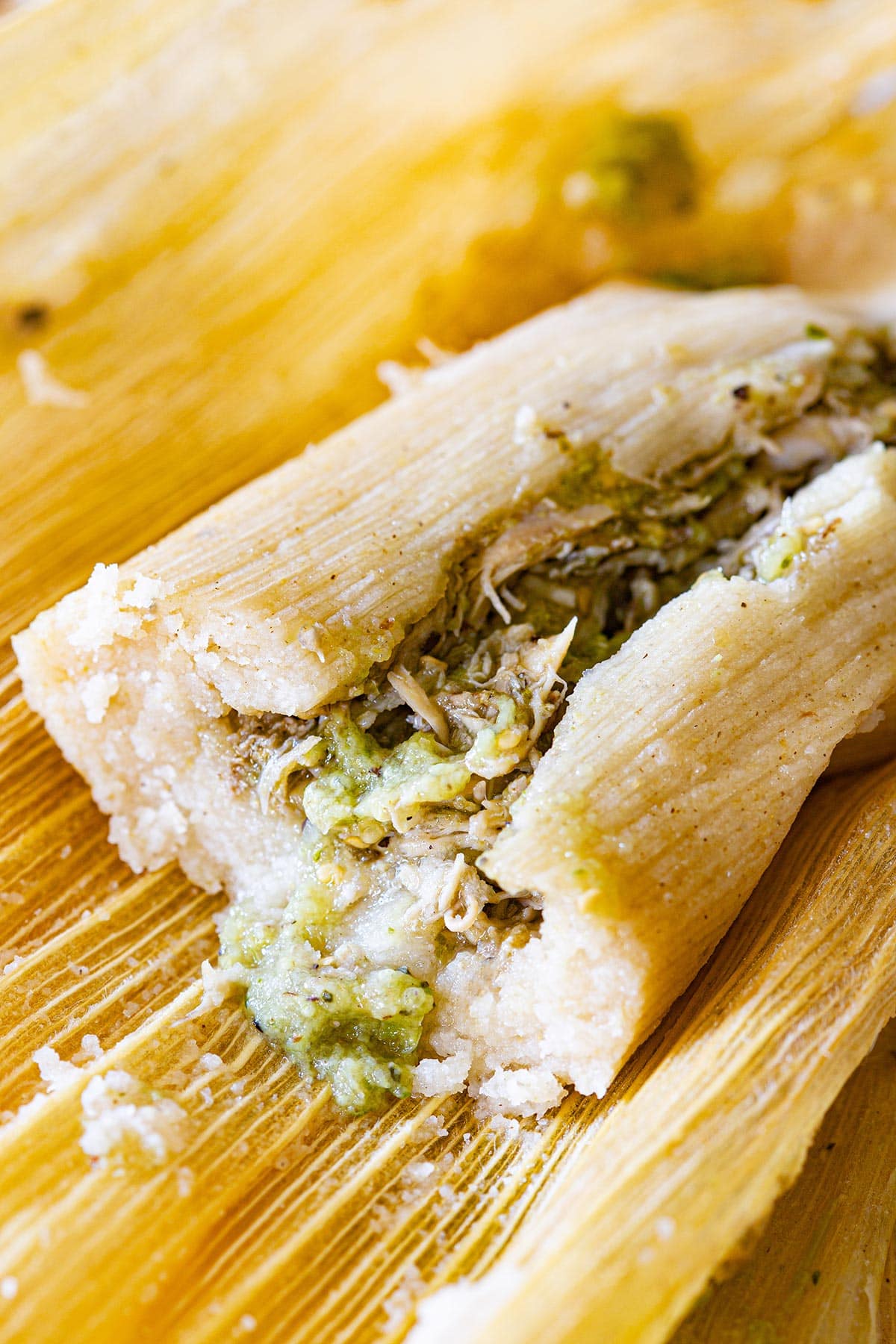 A chicken tamal verde opened to see the filling and texture in the inside.