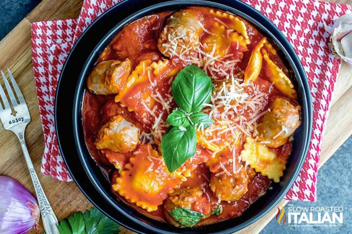 Cheese ravioli with sausage and tomato sauce in a bowl.