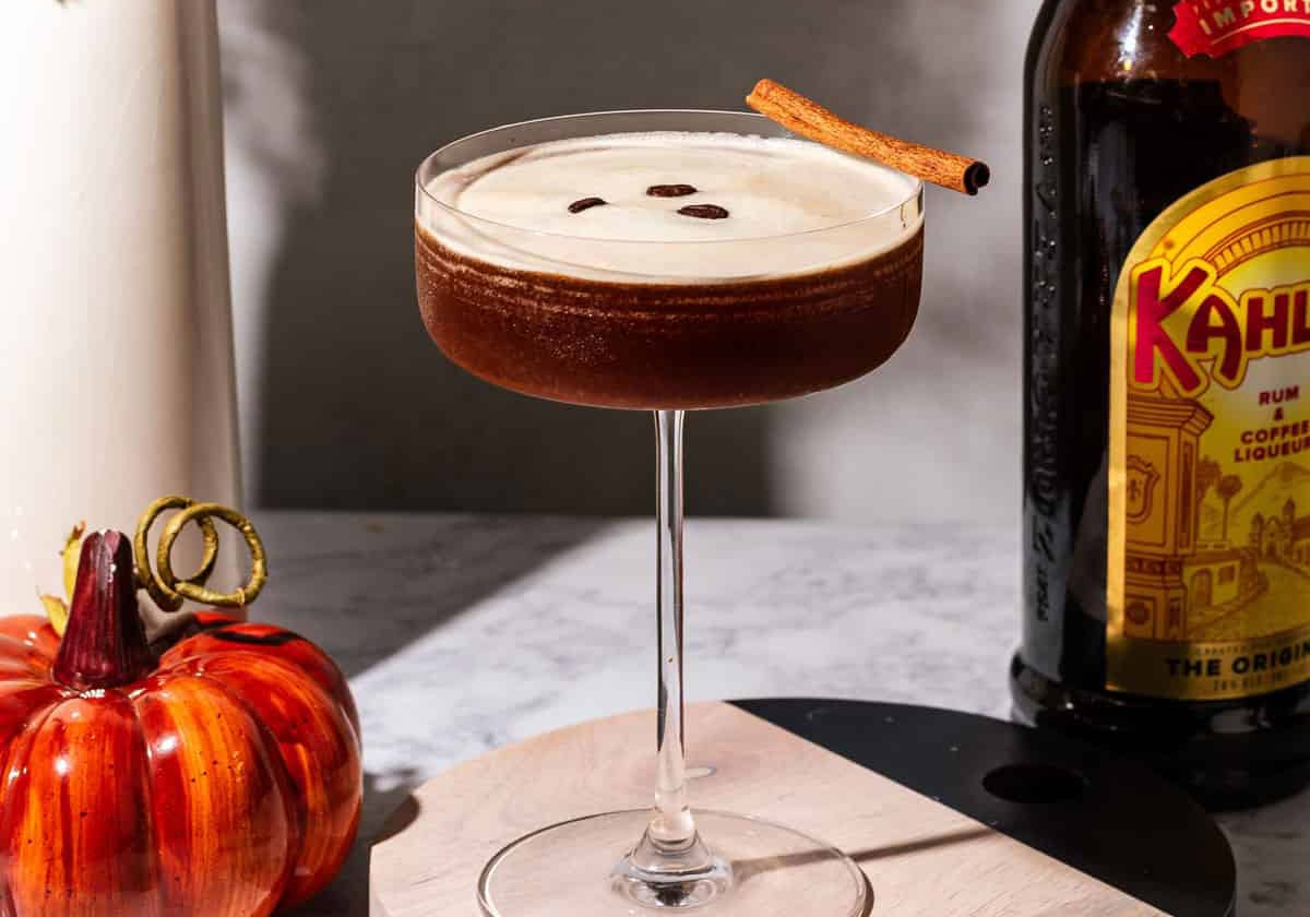 A delicious glass of Pumpkin Spice Espresso Martini garnished with cinnamon stick.