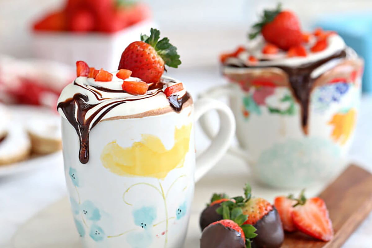 Mugs of hot chocolate with strawberries.