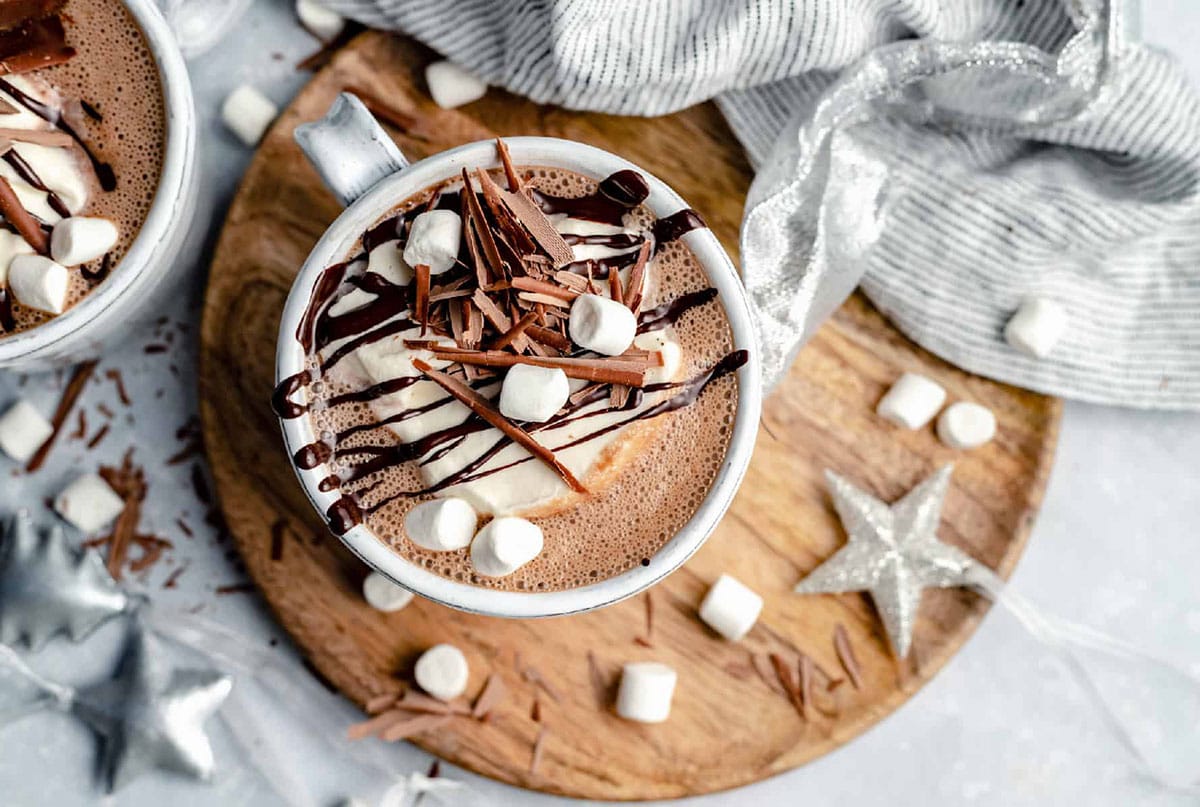 Mugs of cocoa with whipped cream and hazelnuts.