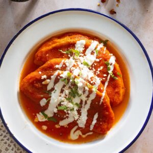 Mexican peqneues de queso in a plate with tomato sauce.