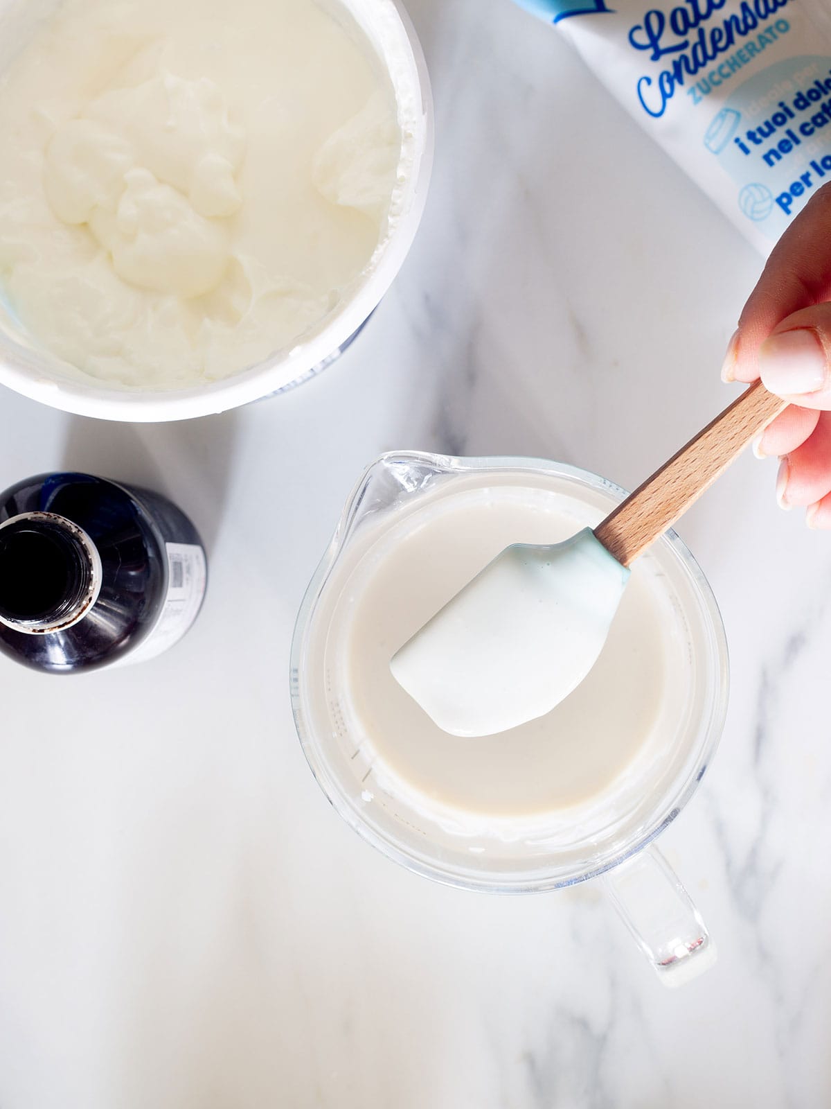 Showing the sweet cream for bionicos with a small spatula.