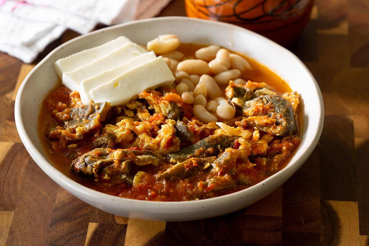 Rajas de chile poblano con huevos. Served in a plate with beans and cheese.