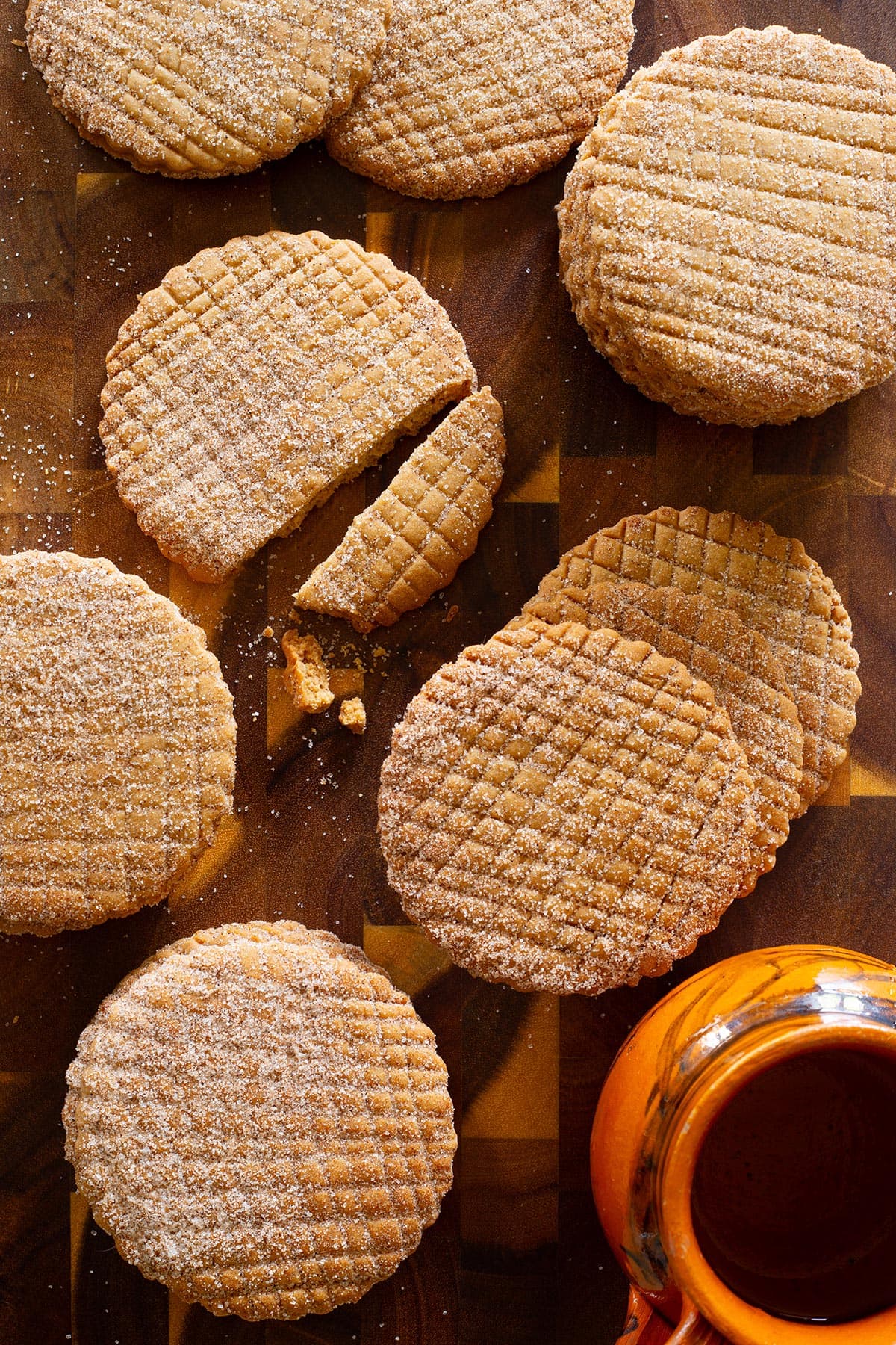 Homemade Canelitas (Galletas de Canela) spread on a table with some cafe de olla on the side.