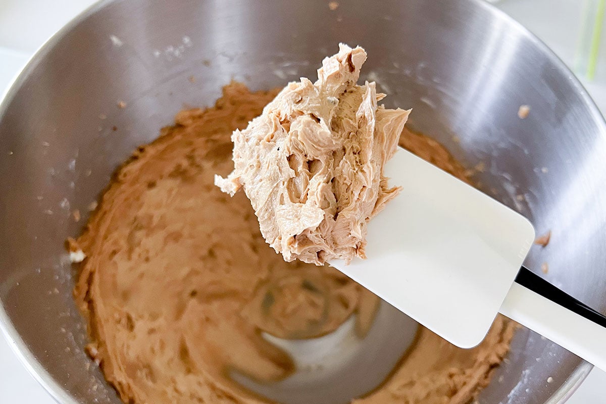 Showing fluffy butter and muscovado sugar with a spatula.