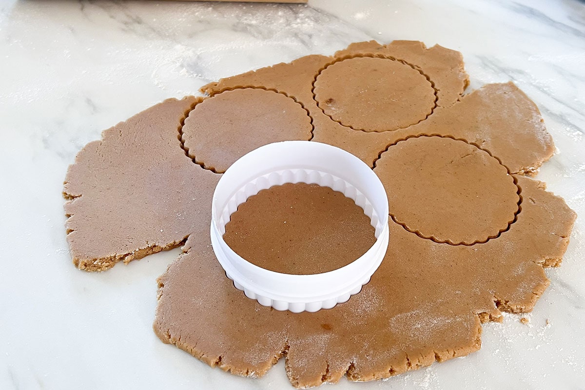 Cutting the dough with a dented cookie cutter.