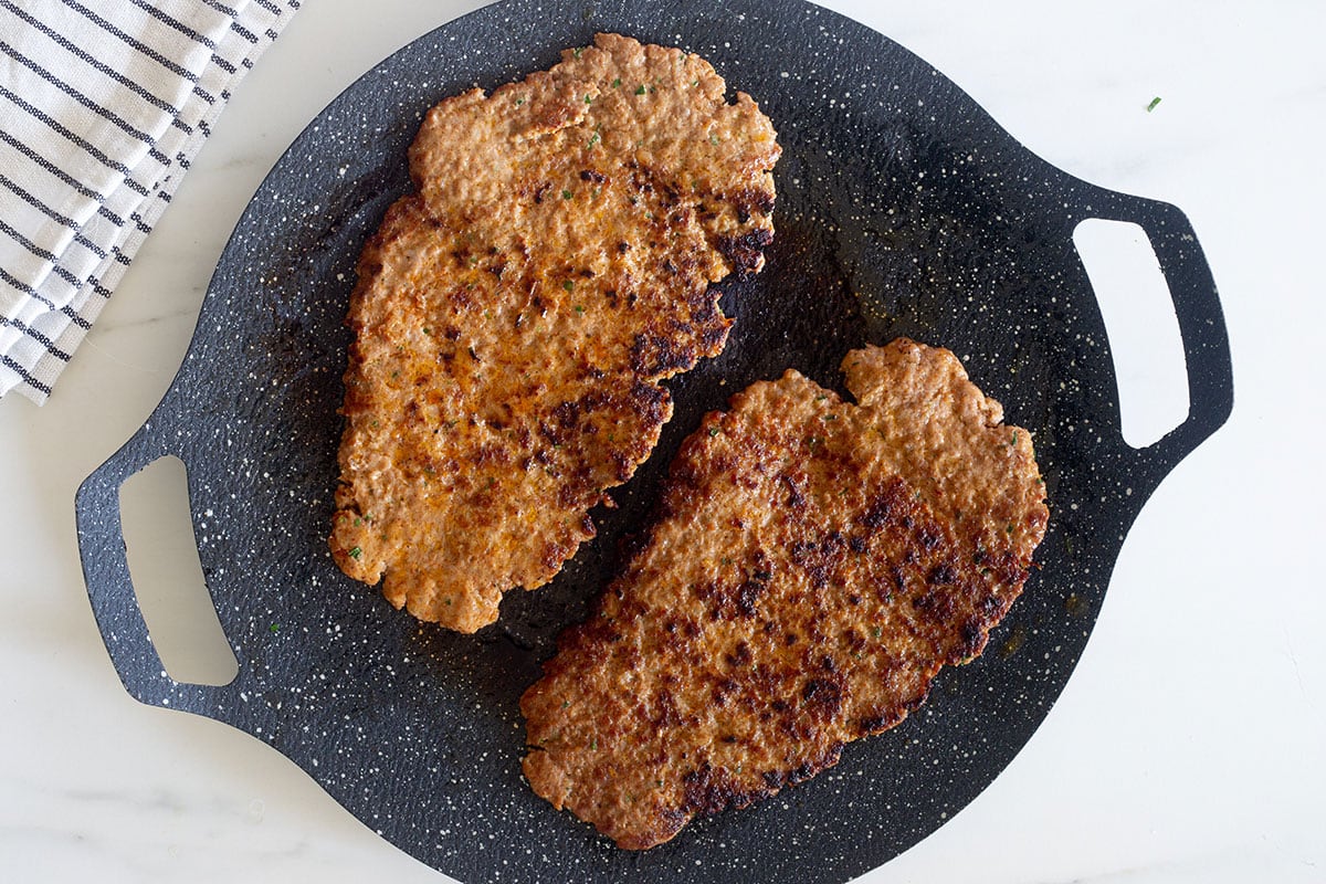 Two Mexican pacholas cooked on a hot griddle.